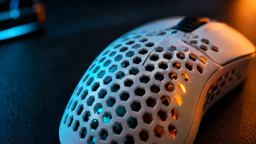 Close-up of a honeycomb-style mouse shell with small holes, one way makers cut weight from a gaming mouse